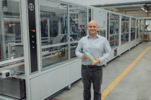 Frugalpac Product Director JP Grogan and the new Frugal Bottle Assembly Machine 2 (FBAM-2)